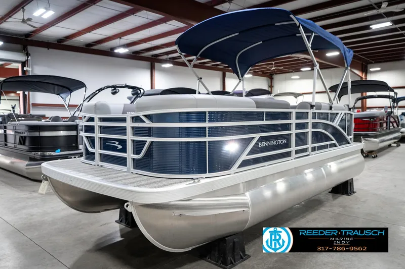 Slide: The Image of 2025 Bennington 18 SLJ pontoon boat with blue canopy in showroom. - 3