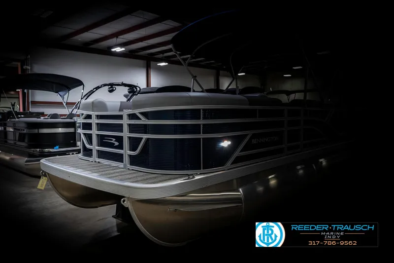 Slide: The Image of 2025 Bennington 18 SLJ pontoon boat in a dimly lit showroom. - 4