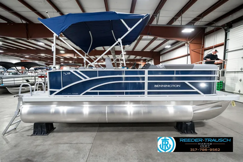 Slide: The Image of 2025 Bennington 18 SLJ pontoon boat with blue canopy in indoor showroom. - 7