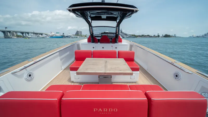 Slide: The Image of 2023 Pardo Yachts 38 with red seating and table on open deck, cruising on calm waters. - 16
