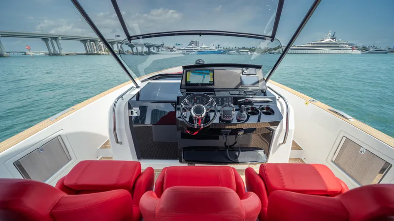 Slide: The Image of 2023 Pardo Yachts 38 helm with red seats, featuring modern navigation equipment, on open water. - 27