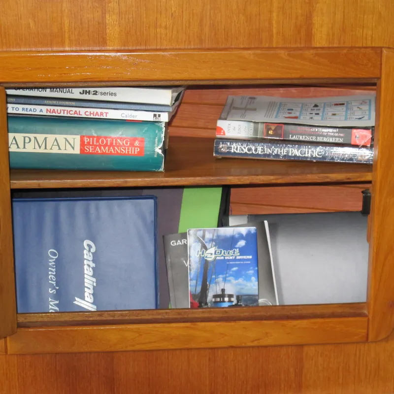 Slide: The Image of Bookshelf with nautical manuals and a 1999 Catalina 42 MkII owner's manual. - 26