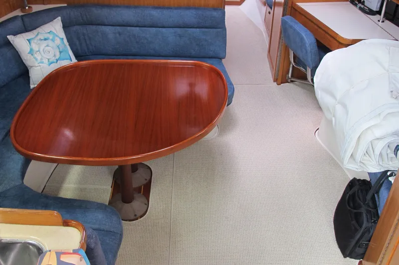 Slide: The Image of Interior of 1999 Catalina 42 MkII sailboat with wooden table and blue seating. - 27