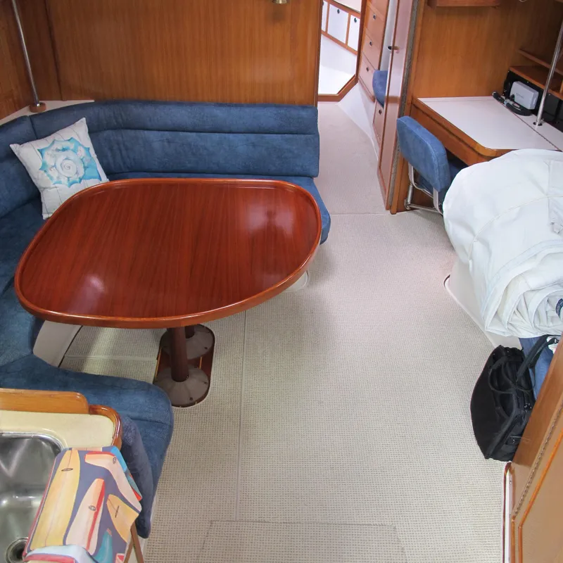 Slide: The Image of Interior of 1999 Catalina 42 MkII sailboat with wooden table and blue seating. - 28