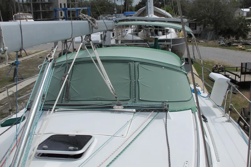 Slide: The Image of 1999 Catalina 42 MkII sailboat with green canopy and rigging, docked at marina. - 3