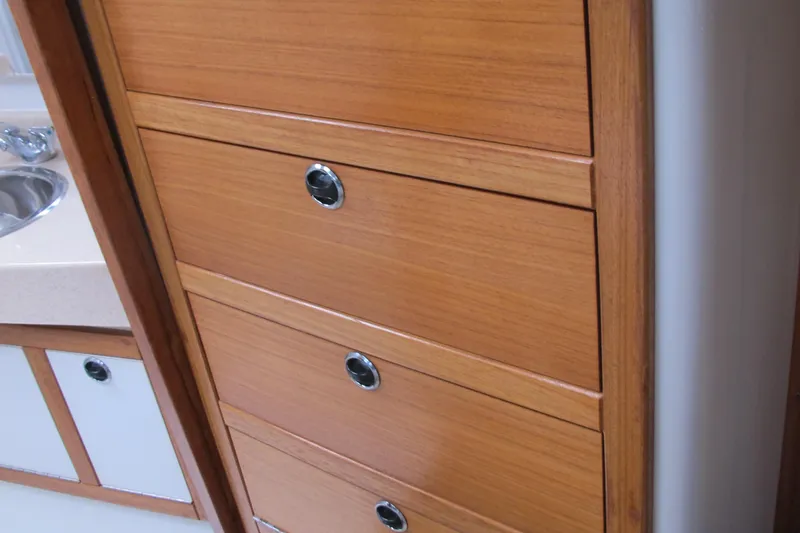 Slide: The Image of Wooden cabinetry inside a 1999 Catalina 42 MkII yacht, featuring sleek drawers and a sink. - 43