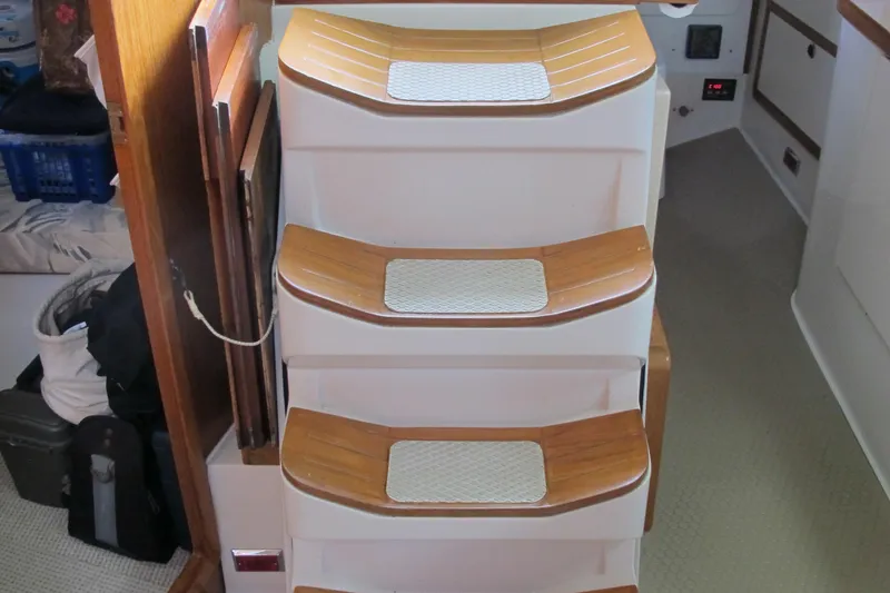 Slide: The Image of Staircase inside 1999 Catalina 42 MkII yacht with wooden steps and white accents. - 44