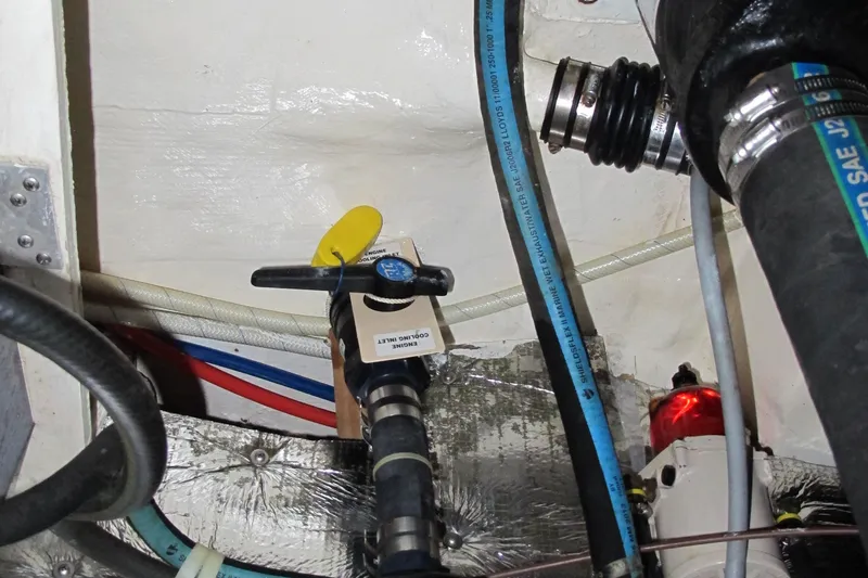 Slide: The Image of Engine compartment of a 1999 Catalina 42 MkII sailboat, showing hoses and valves. - 47