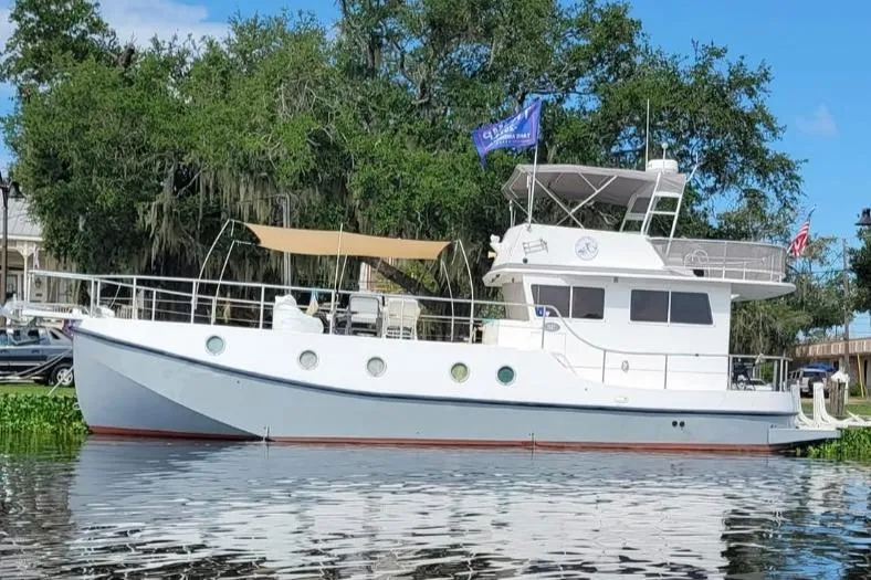 Slide: The Image of 2007 Great Harbour N47 yacht docked by lush greenery and calm water. - 1