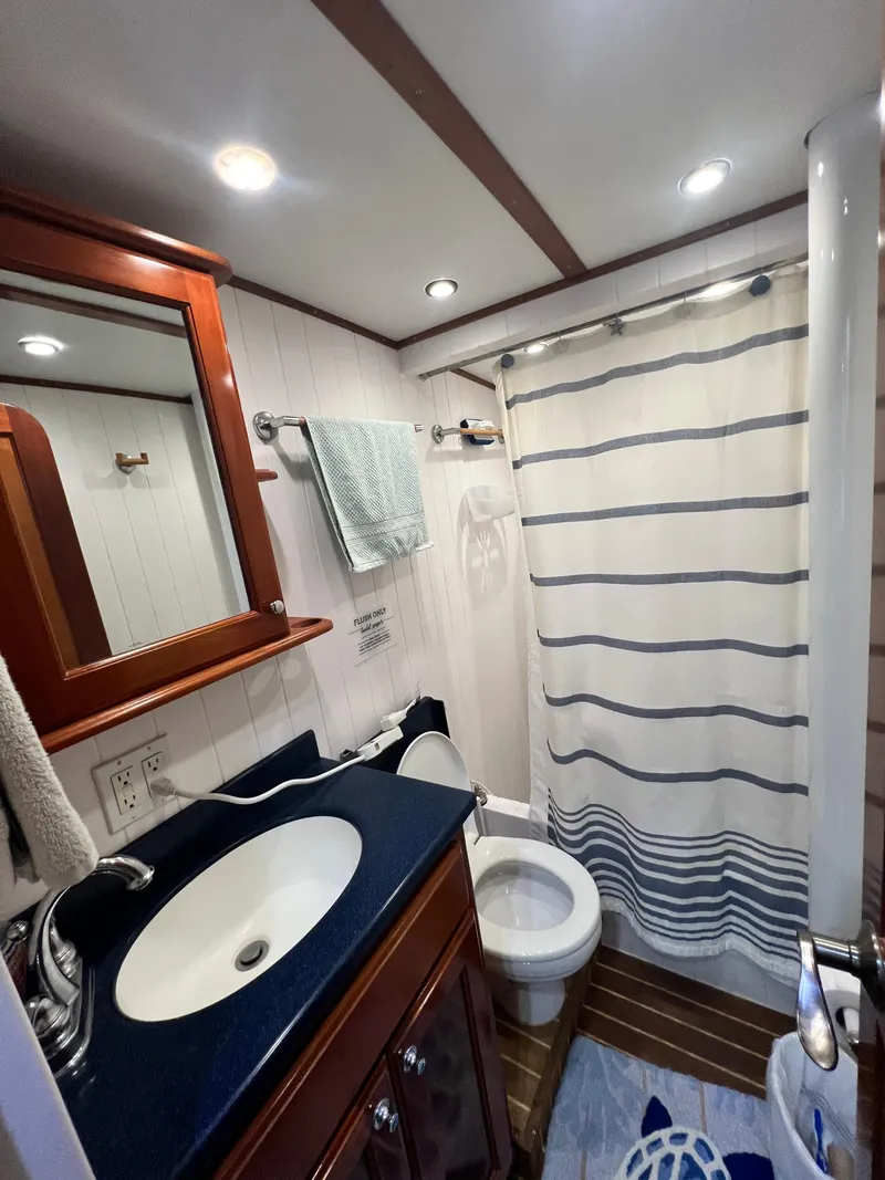 Slide: The Image of Bathroom interior of 2007 Great Harbour N47 yacht with sink, toilet, and striped shower curtain. - 12