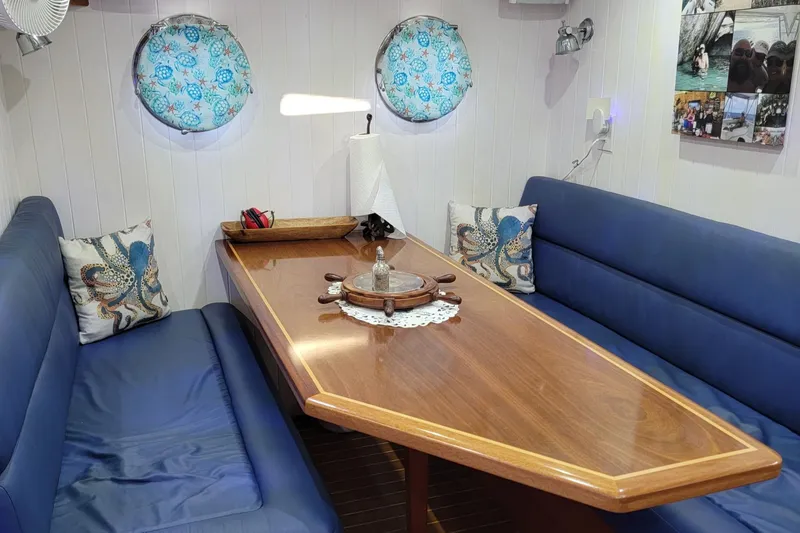 Slide: The Image of Cozy interior of 2007 Great Harbour N47 yacht with blue seating and wooden table. - 6