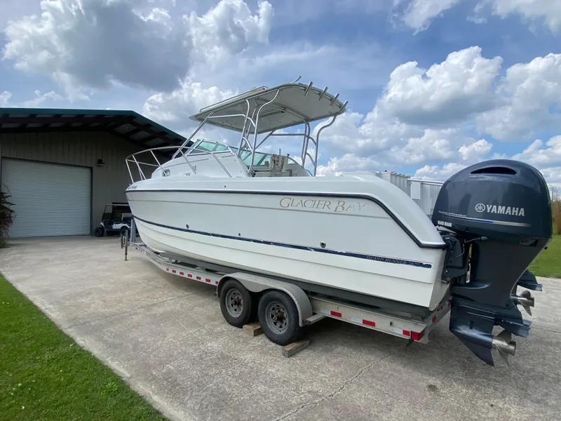 Slide: The Image of 2001 Glacier Bay 2670 Island Runner boat on trailer, parked outdoors under cloudy sky. - 10