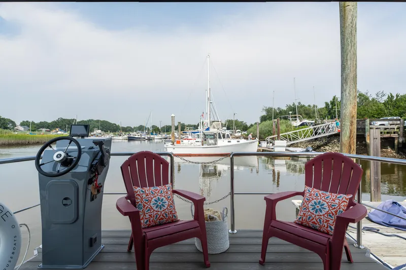 Slide: The Image of Outdoor seating on Waterlodge Apart M 2024, overlooking marina and lush landscape. - 25