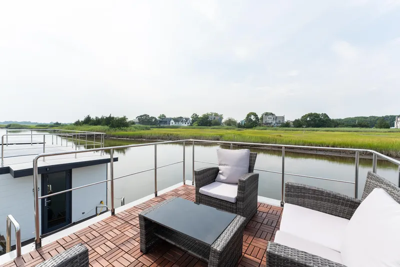 Slide: The Image of Modern 2024 Waterlodge Apart M houseboat with wooden exterior and rooftop seating. - 29