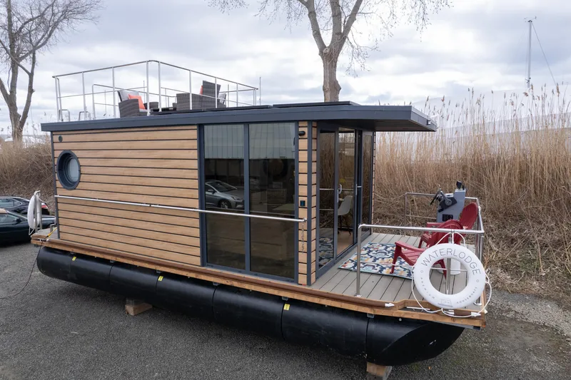 Slide: The Image of Houseboat deck with red chairs, steering wheel, and colorful rug, Waterlodge Apart M 2024 model. - 34