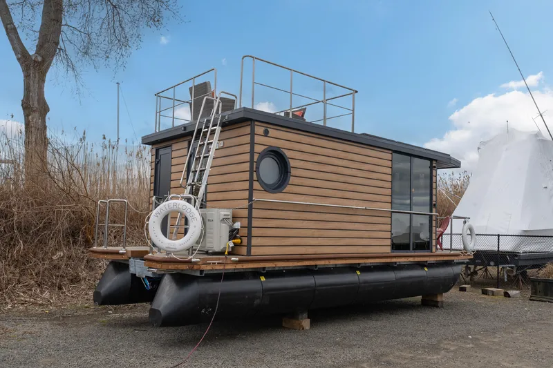 Slide: The Image of Modern 2024 Waterlodge Apart M houseboat with wooden exterior and rooftop access ladder. - 42