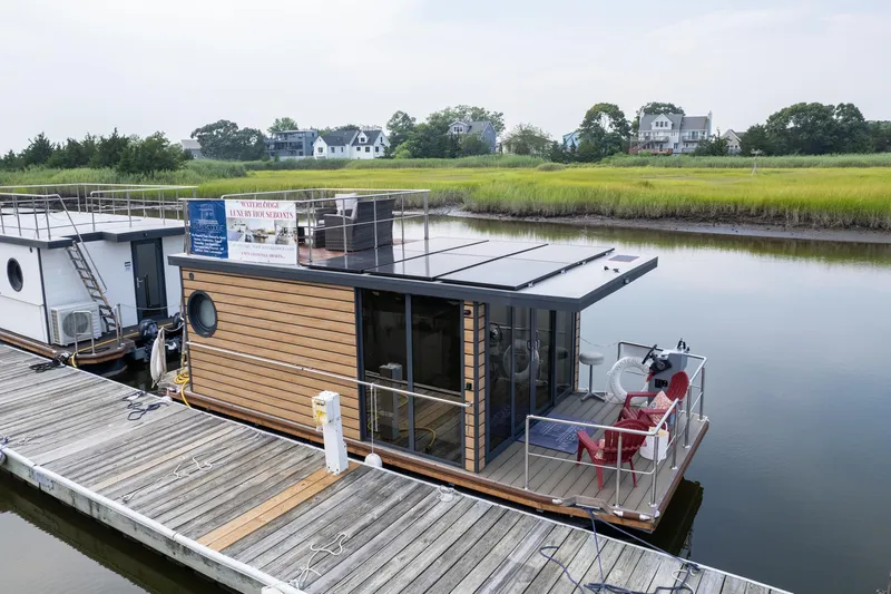 Slide: The Image of Aerial view of 2024 Waterlodge Apart M houseboat with solar panels and outdoor seating. - 8