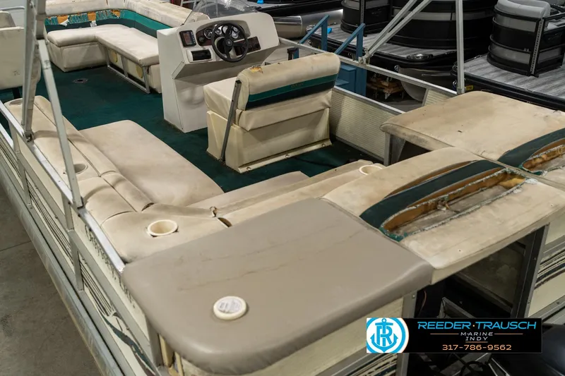 Slide: The Image of 1998 Odyssey 25 pontoon boat interior with seating and steering console. - 15