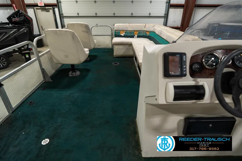 Slide: The Image of Interior of a 1998 Odyssey 25 boat with green carpet and white seating. - 20
