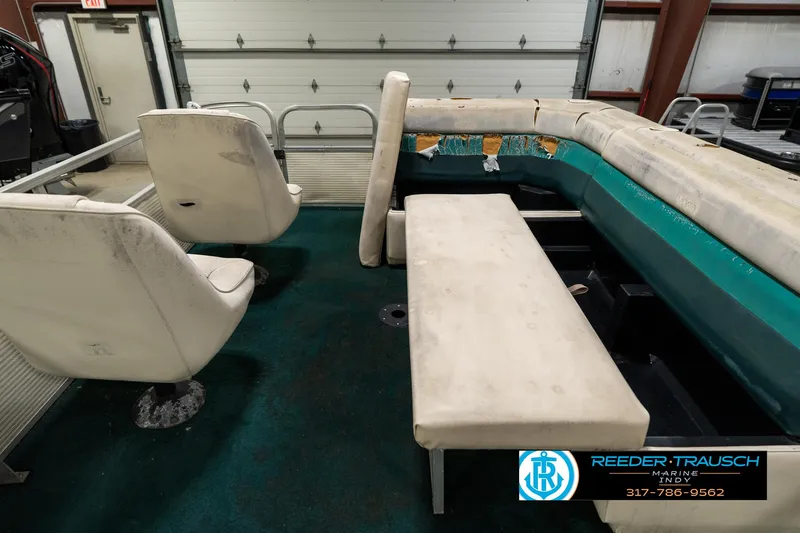 Slide: The Image of 1998 Odyssey 25 boat interior with worn seating and green carpet. - 22