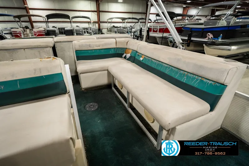 Slide: The Image of 1998 Odyssey 25 boat interior with worn seating in a showroom. - 23