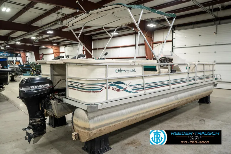 Slide: The Image of 1998 Odyssey 25 pontoon boat in indoor storage with Tracker outboard motor. - 8