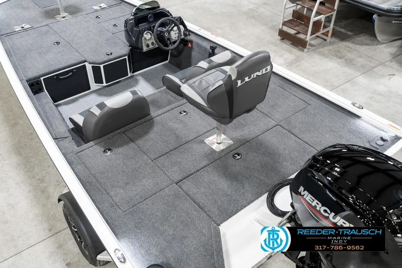 Slide: The Image of 2025 Lund 1775 Renegade boat interior with Mercury engine, featuring gray seating and steering console. - 13