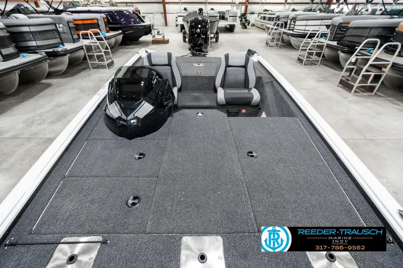 Slide: The Image of 2025 Lund 1775 Renegade boat interior in showroom, featuring spacious seating and modern design. - 17