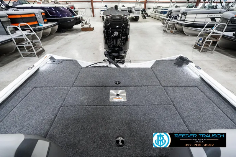Slide: The Image of 2025 Lund 1775 Renegade boat in showroom, featuring spacious deck and powerful outboard motor. - 19