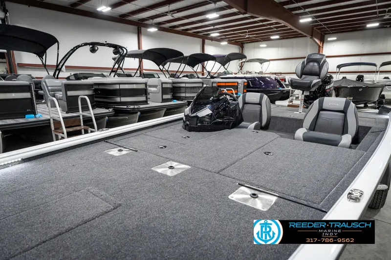 Slide: The Image of 2025 Lund 1775 Renegade boat in showroom, featuring spacious deck and seating. - 21