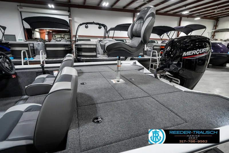 Slide: The Image of 2025 Lund 1775 Renegade boat interior with seating and Mercury engine in showroom. - 25