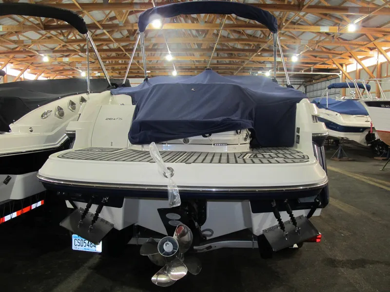 Slide: The Image of 2012 Monterey 264FS boat in storage, covered, with visible propellers and swim platform. - 3