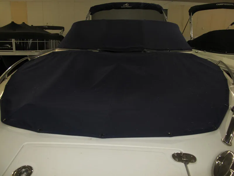 Slide: The Image of 2012 Monterey 264FS boat with dark cover, docked indoors. - 4