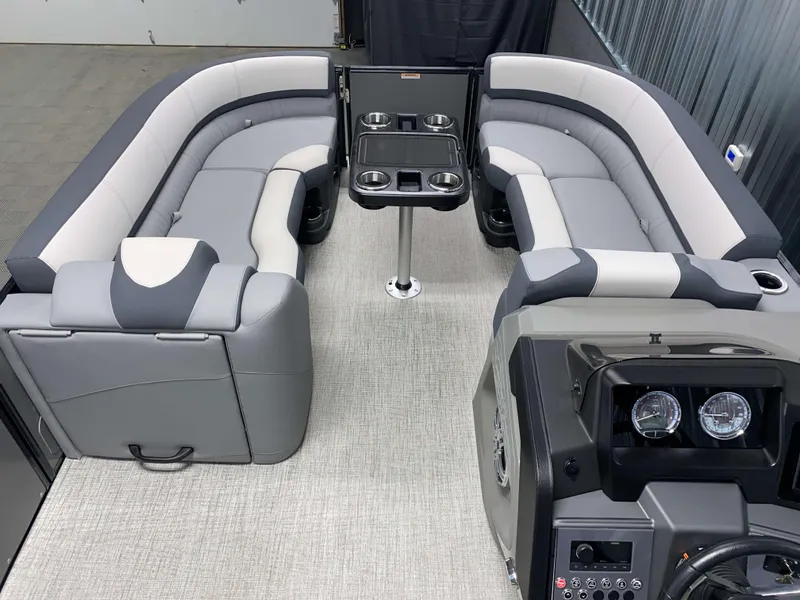 Slide: The Image of 2025 Avalon Catalina 2385 QLS Tritoon interior with gray seating and central table. - 13