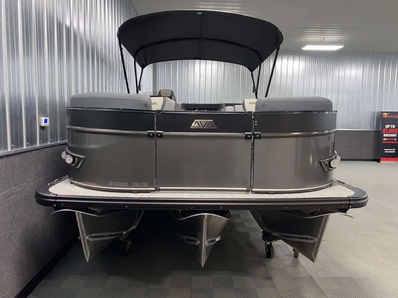 Slide: The Image of 2025 Avalon Catalina 2385 QLS Tritoon in showroom, sleek design, black canopy. - 16