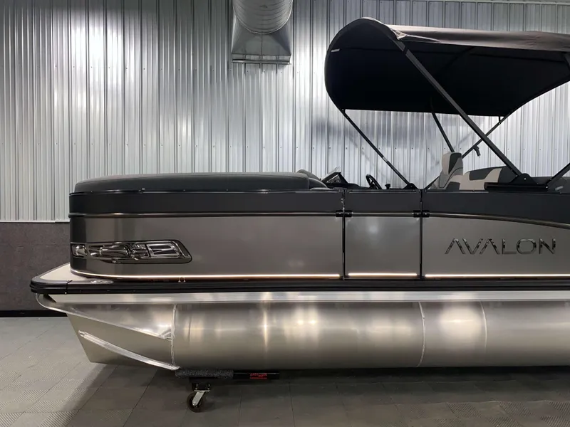 Slide: The Image of 2025 Avalon Catalina 2385 QLS Tritoon in showroom, sleek design, metallic finish. - 18
