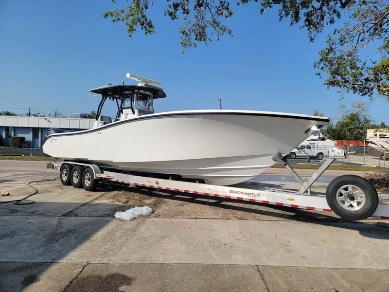 Slide: The Image of 2014 Yellowfin 36 boat on trailer, parked outdoors under clear blue sky. - 1