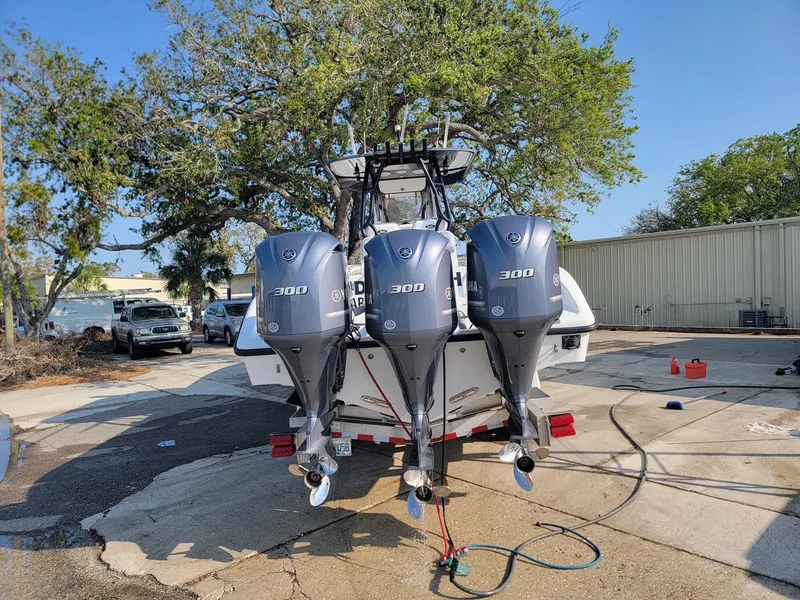 Slide: The Image of 2014 Yellowfin 36 boat with triple 300 horsepower outboard engines, parked outdoors. - 21