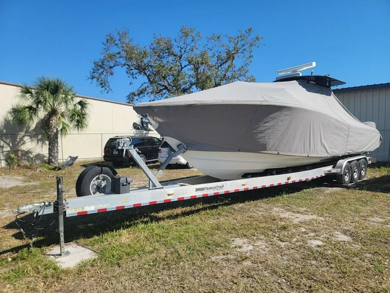 Slide: The Image of Covered 2014 Yellowfin 36 boat on trailer, parked outdoors under clear blue sky. - 22