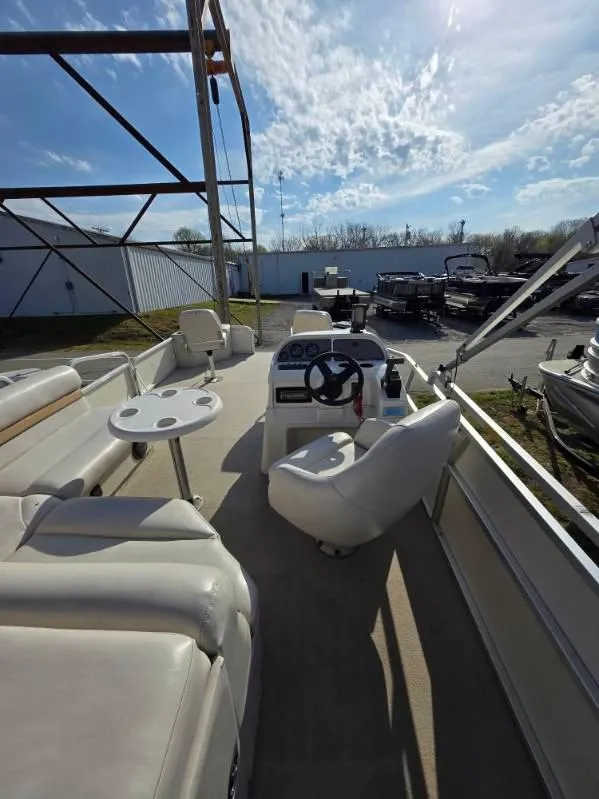 Slide: The Image of 2004 SunCatcher G3 22C pontoon boat with seating and steering console, docked outdoors. - 16