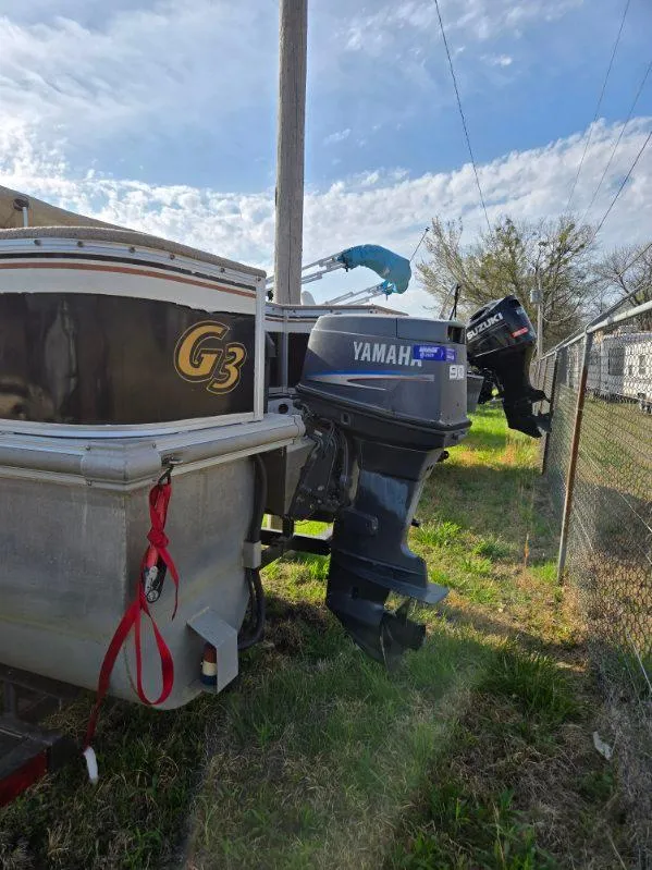 Slide: The Image of 2004 SunCatcher G3 22C boat with Yamaha outboard motor, parked outdoors. - 4