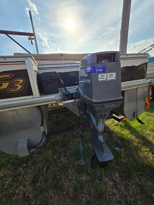 Slide: The Image of 2004 SunCatcher G3 22C pontoon boat with Yamaha 90 outboard motor, parked on grass. - 6