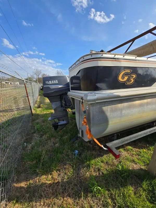 Slide: The Image of 2004 SunCatcher G3 22C boat with Yamaha motor, parked on grass under blue sky. - 7