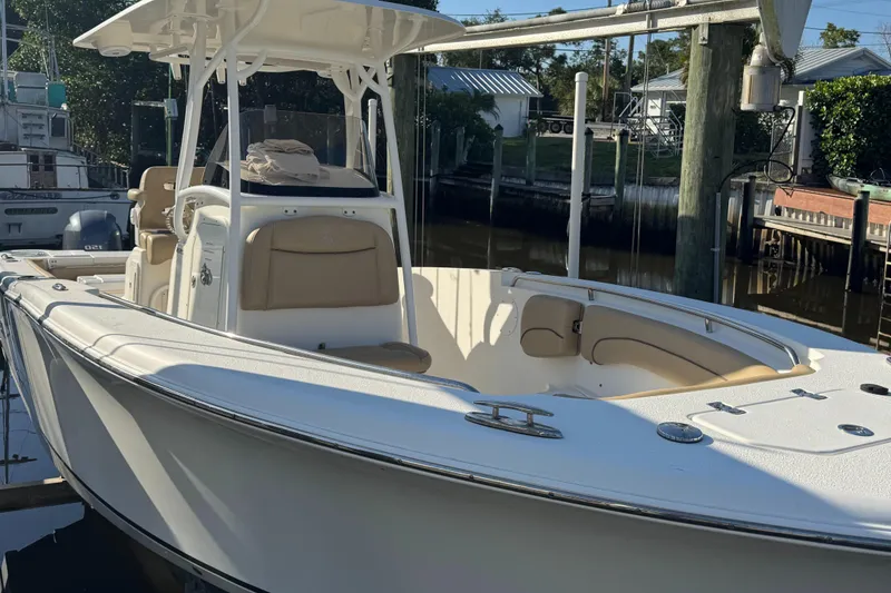 Slide: The Image of 2019 NauticStar 25XS boat docked, featuring sleek design and spacious seating. - 10