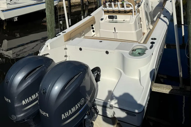 Slide: The Image of 2019 NauticStar 25XS boat with dual outboard motors docked. - 14