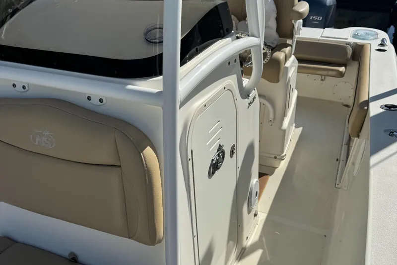 Slide: The Image of 2019 NauticStar 25XS boat interior with beige seating and console. - 8