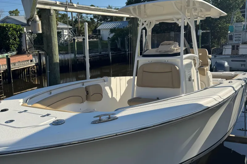 Slide: The Image of 2019 NauticStar 25XS boat docked in a marina, featuring a sleek white design. - 9