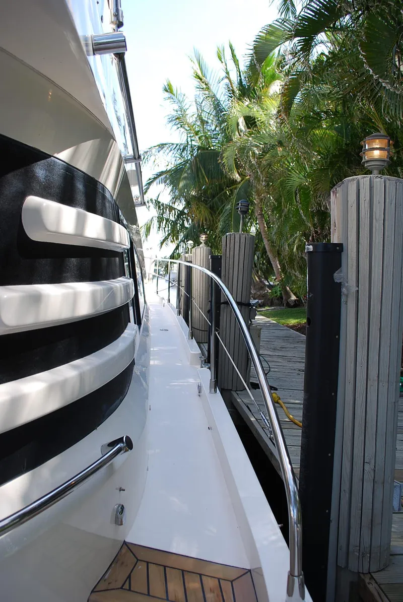 Slide: The Image of Side view of a 2000 Fairline Squadron yacht docked near tropical foliage. - 10