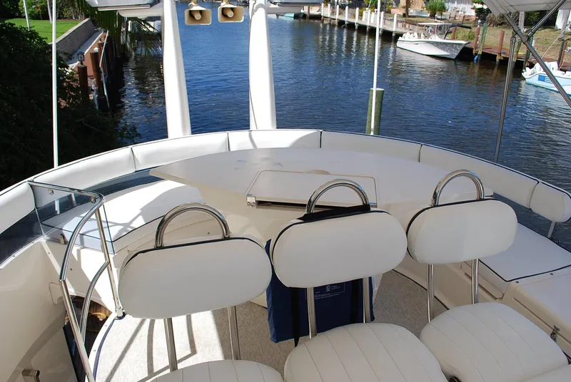 Slide: The Image of Luxury Fairline Squadron 2000 yacht deck with white seating overlooking serene waterfront. - 13
