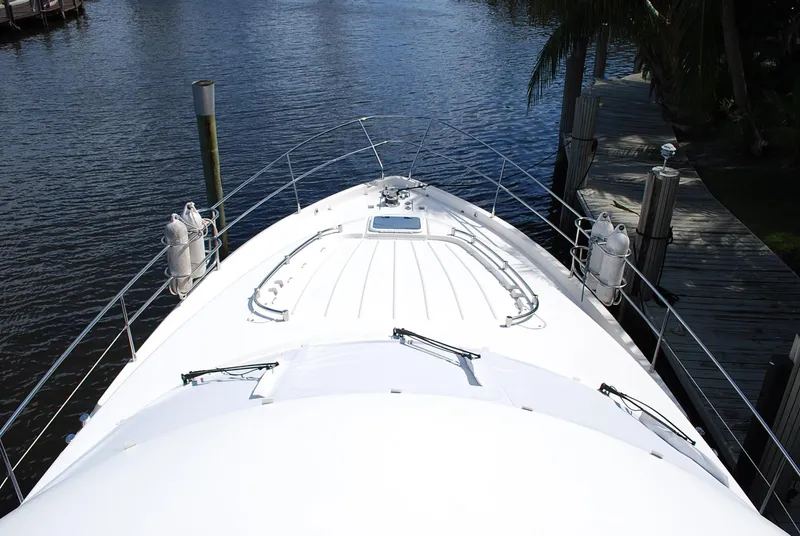 Slide: The Image of Bow view of 2000 Fairline Squadron yacht docked by a serene waterfront. - 4